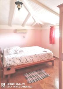 Appartement confortable avec vue sur mer à Deshaies, 48 m² في ديساي: غرفة نوم بسرير ومقعد في غرفة