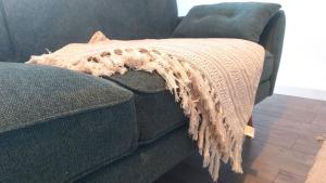 a blanket on the side of a couch at Zentrale, gemütliche Dachgeschoss-Etage - 52qm - Altes Haus auf 2,5 Etagen exklusiv für Dich - mit 1 Schlafzimmer, Wohnzimmer und Rückzugsraum zum Verweilen - Küche, großes Bad, Netflix in Halle an der Saale