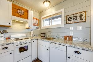 a kitchen with white cabinets and a sink at Hike, Boat, Fish and More Table Rock Lake Cottage in Cape Fair