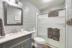 a bathroom with a toilet and a sink and a mirror at Hike, Boat, Fish and More Table Rock Lake Cottage in Cape Fair +28 photos