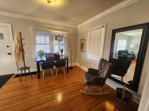sala de estar con espejo, silla y escritorio en Katherine's Cozy Bungalow, en Terre Haute
