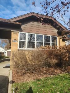 una casa con grandes ventanas en un patio en Katherine's Cozy Bungalow, en Terre Haute