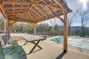 a wooden pergola with a table and a picnic table at Bass Fishing Paradise Cottage on Table Rock Lake in Cape Fair