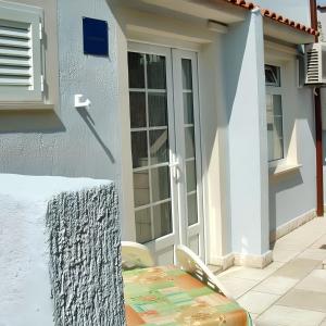 a door of a house with a table and chairs at Charming apartment in Kampor with private garden - 28 m² in Kampor +4 photos