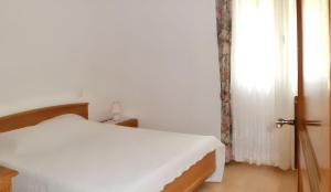 a white bedroom with a bed and a window at Maison chaleureuse à Nages avec vue sur lac et montagne in Nages