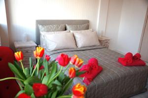 un letto con due cuori rossi e un mazzo di fiori di Athens Point ad Atene