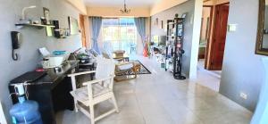 a living room with a counter and chairs in it at Sol Mar Alegre II in Boca Chica +8 photos