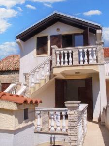 ein weißes Haus mit einer Treppe und einem Balkon in der Unterkunft Spacious Apartment in Zlarin + terrace in Zlarin