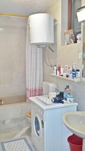 ein Badezimmer mit Waschmaschine und Waschbecken in der Unterkunft Spacious Apartment in Zlarin + terrace in Zlarin