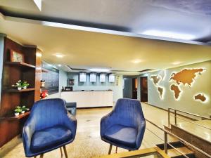 a waiting room with two blue chairs in a hospital at Aditya inn Delhi Airport in New Delhi