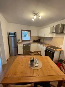 a kitchen with a wooden table and a kitchen with a refrigerator at Ferienhaus Groß Grönau in Groß Grönau