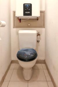 a bathroom with a toilet with a clock on the wall at Appartement convivial à Gassin 37 m² avec vue sur la mer in Gassin +6 photos