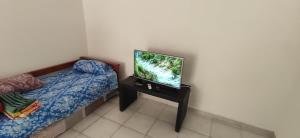 a bedroom with a bed and a television on a table at Deptos a cuadras del corsodromo in Gualeguay +4 photos
