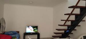 a living room with a tv and a staircase at Dpto GAMA a cuadras del corso in Gualeguay +13 photos