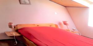 a bedroom with a red bed with two lamps at Appartement accueillant à Selonnet de 80 m² avec piscine partagée in Selonnet +21 photos
