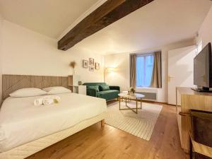 ein Schlafzimmer mit einem großen Bett und einem grünen Sofa in der Unterkunft Le Studio Green - 2 people in Chartres