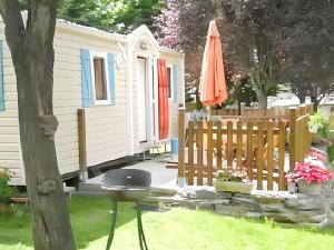 ein kleines Häuschen mit Grill und Sonnenschirm in der Unterkunft Charmant Bungalow à Juncalas avec Terrasse et Vue Montagne in Juncalas + 6 Fotos