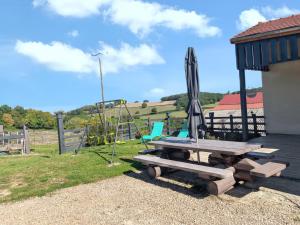 a picnic table with an umbrella and a swing at Maison charmante à Bousson le Haut + Terrasse ensoleillée in Quarré-les-Tombes