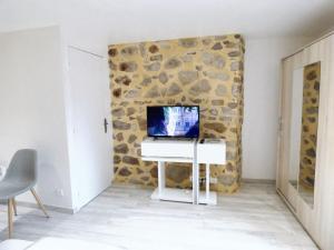 a room with a stone wall with a computer on a desk at Maison confortable au cœur de Brioude avec parking privé. in Brioude