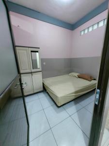 a small bedroom with a bed and a mirror at pondok Syariah Hadikusuma in Rahayu