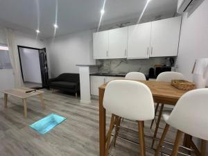 a kitchen and a dining room with a table and chairs at Loft San Carlos in Alicante