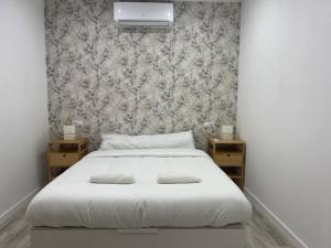 a bedroom with a white bed with two night stands at Loft San Carlos in Alicante +12 photos