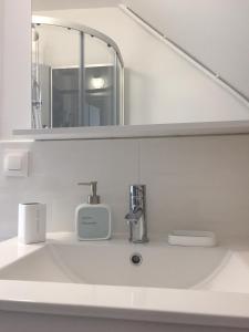 a bathroom with a sink and a mirror at Appt au pied de la cathédrale avec parking gratuit in Amiens