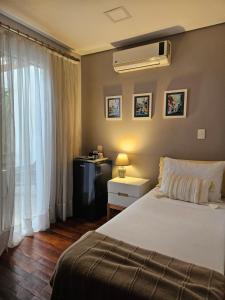 a bedroom with a bed and a desk and a window at Casa Garay Hotel 658 in Asuncion