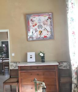a picture on the wall above a wooden dresser at Maison accueillante à Arles - Jardin, Parking privé in Arles