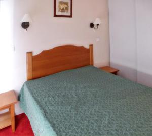 a bedroom with a bed with a green comforter at Appartement accueillant Saint-Lary-Soulan 45 m² Piscine partagée in Saint-Lary-Soulan