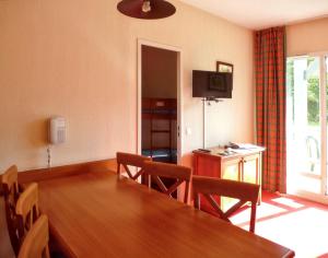 a living room with a table and chairs and a television at Appartement accueillant Saint-Lary-Soulan 45 m² Piscine partagée in Saint-Lary-Soulan