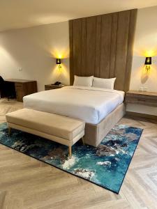 a bedroom with a large white bed and a blue rug at Lahore Grande Boutique Hotel in Lahore
