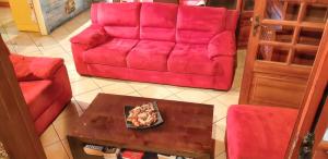 a living room with a red couch and a table at Appartement spacieux aux Trois-Îlets avec piscine partagée in Les Trois-Îlets +26 photos