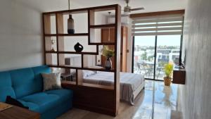 a bedroom with a bed and a blue couch at Playa del Carmen - Playaquerida in Playa del Carmen