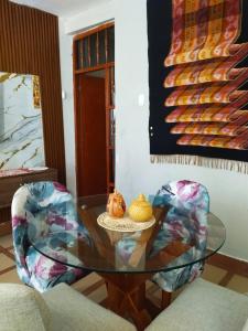 a glass table in a living room with two chairs at Alojamiento & Místico in Ayacucho