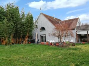 a white house with a yard at Villa élégante à Château-la-Vallière avec piscine privée in Château-la-Vallière