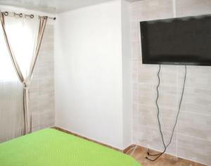 Zimmer mit einem Flachbild-TV an der Wand in der Unterkunft Villa charmante à Le Tampon + Piscine in Le Tampon
