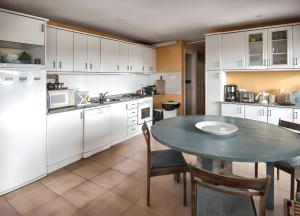 a kitchen with a table and white cabinets at Spacious house with sea view in Liencres + jacuzzi in Liencres