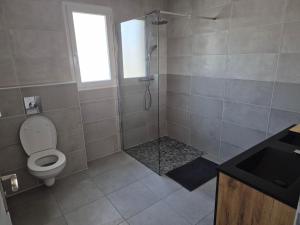 a bathroom with a toilet and a glass shower at Belle Maison 3 Chambres 9 Personnes Grayan et L'Hopital in Grayan-et-lʼHôpital +13 photos