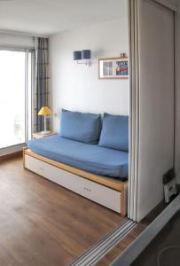 a bed with blue pillows in a room at Charmant studio vue mer à Pornichet 30 m² avec terrasse in Pornichet +39 photos