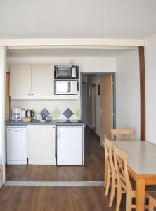 an open kitchen and dining room with a table and chairs at Charmant studio vue mer à Pornichet 30 m² avec terrasse in Pornichet