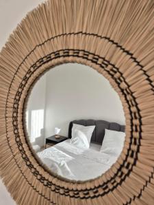 a mirror reflecting a bed in a bedroom at Belle Maison 3 Chambres 9 Personnes Grayan et L'Hopital in Grayan-et-lʼHôpital