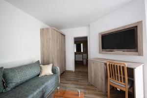a living room with a couch and a flat screen tv at Casa Dacia in Eşelniţa