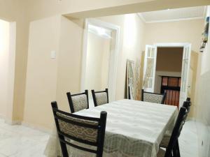 Un comedor con una mesa y sillas blancas. en Departamento San Martín I, en Paso de los Libres