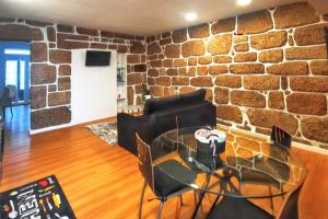 a room with a brick wall and a table and chairs at Charming apartment in Guimarães of 70 m² in Guimarães