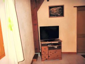 TV en un tocador de madera en una habitación en Charmante maison à Sarrazac avec piscine privée, en Sarrazac