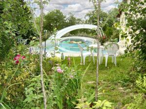 un jardín con mesa y sillas y una piscina en Charmante maison à Sarrazac avec piscine privée, en Sarrazac