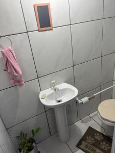 a bathroom with a white sink and a toilet at Casa com Área Gourmet na Praia de Fora in Palhoça +16 photos