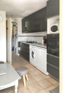 a kitchen with a washing machine and a microwave at Charmant appartement avec piscine partagée à Agde in Cap d'Agde