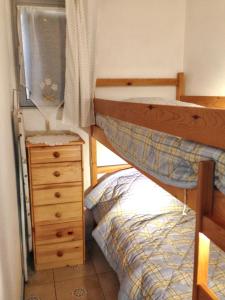 a small bedroom with a bunk bed and a dresser at Charmant appartement avec piscine partagée à Agde in Cap d'Agde
